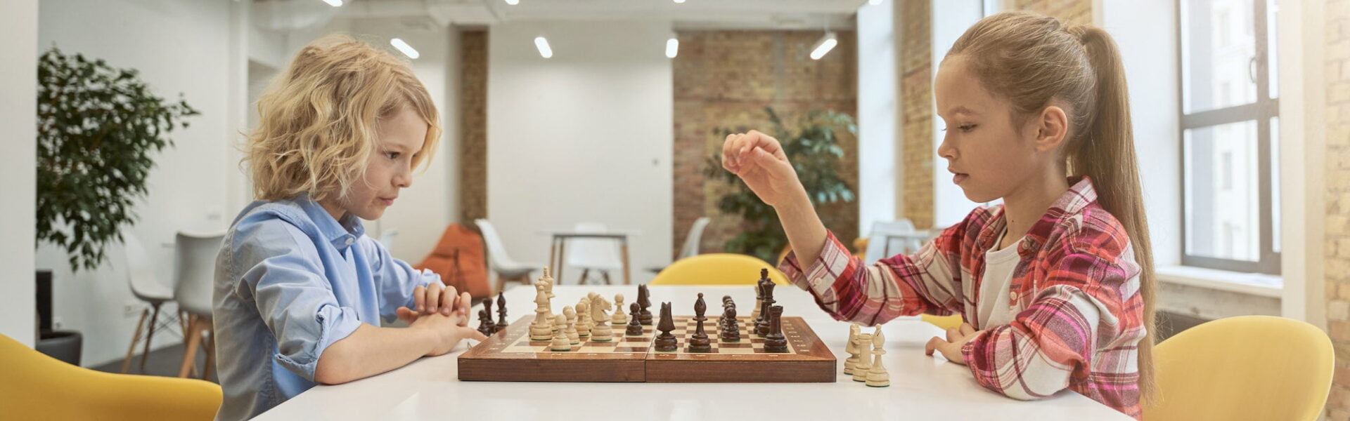 Two smart little children boy and girl developing chess strategy playing board game sitting - Image from Inkfire Limited